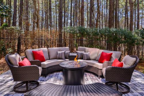 a patio with two couches and a table with red pillows at Country Inn & Suites by Radisson Raleigh-Durham Airport NC in Morrisville