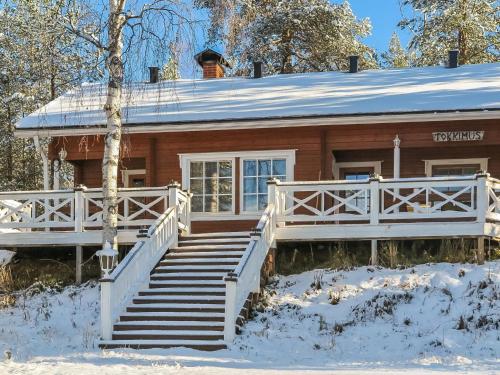 una casa con una escalera en la nieve en Holiday Home Tokkimus by Interhome, en Luosto