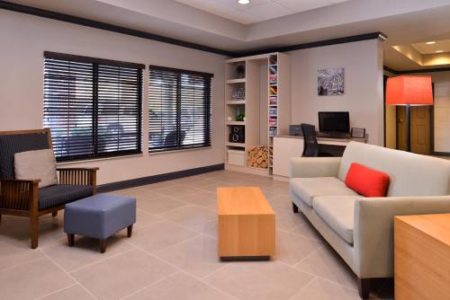 a living room with a couch and a table at Country Inn & Suites by Radisson Raleigh-Durham Airport NC in Morrisville