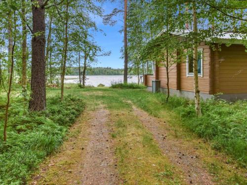 a dirt road in front of a house with trees at Holiday Home Koivuranta by Interhome in Oravi