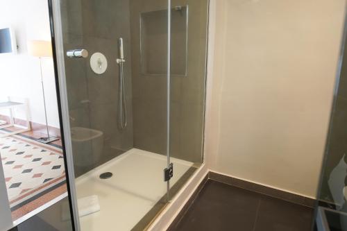 a shower with a glass door in a bathroom at Le Stanze di Piazza Cairoli in Messina