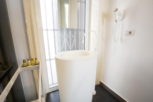 a bathroom with a white sink next to a window at Le Stanze di Piazza Cairoli in Messina