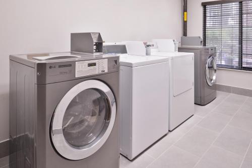 a washing machine and a dryer in a laundry room at Country Inn & Suites by Radisson Raleigh-Durham Airport NC in Morrisville