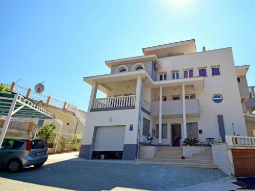 Biały dom z samochodem zaparkowanym przed nim w obiekcie Apartment Anđa-1 by Interhome w Trogirze