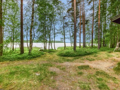 a view of the beach from the woods at Holiday Home Mäntyranta by Interhome in Harjula