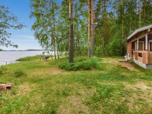 a cabin in the woods next to the water at Holiday Home Koivuranta by Interhome in Oravi