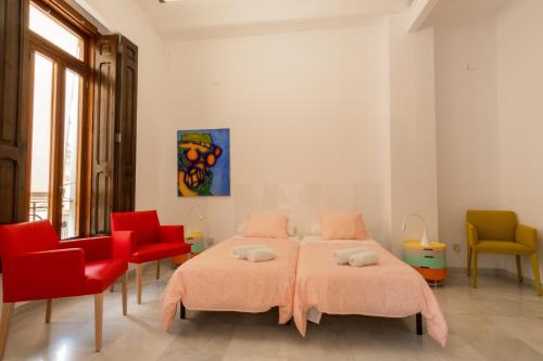 a bedroom with two beds and red chairs at Style Peydro Apartament. Center-Wifi in Valencia