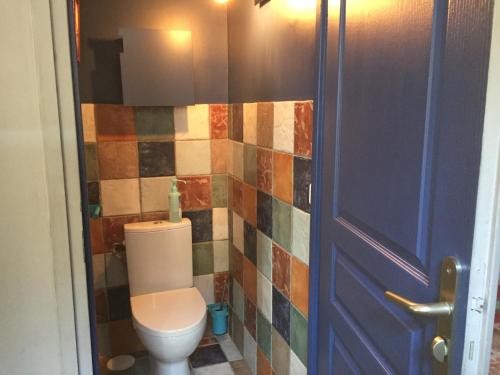 une salle de bain avec toilettes et un mur carrelé dans l'établissement Maison de maitre, coeur de ville., à Sète