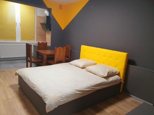 1 cama con cabecero amarillo en una habitación en VIP apartment in the centre, en Uzhhorod