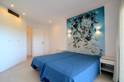 レスカラにあるPASSEIG DEL MAR 9 2.2のベッドルーム1室(壁に絵画が描かれた青いベッド1台付)