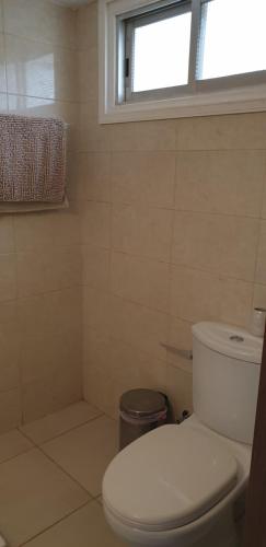 een badkamer met een wit toilet en een raam bij EMILIA 10 STUDIO in Polis Chrysochous