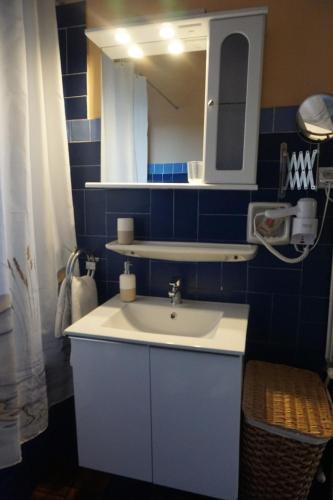 W łazience znajduje się biała umywalka i lustro. w obiekcie Acharavi Afrodite Apartments w Acharavi