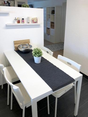 a white dining room table with white chairs at Ferienwohnung Erlinsbach SO in Niedererlinsbach
