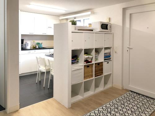 a kitchen with white cabinets and a white microwave at Ferienwohnung Erlinsbach SO in Niedererlinsbach