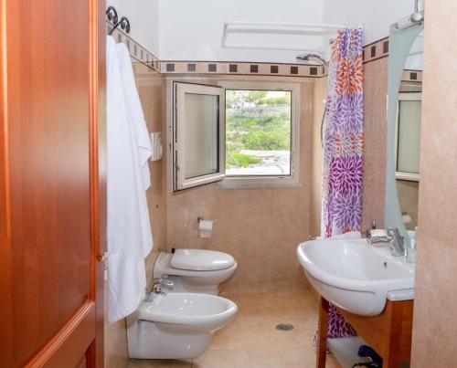 La salle de bains est pourvue de toilettes, d'un lavabo et d'une fenêtre. dans l'établissement Casa MareLuna, à Vico Equense