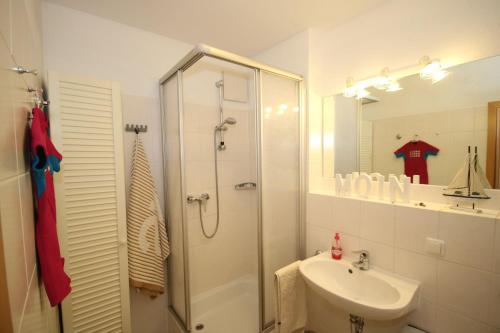 a white bathroom with a shower and a sink at GODS06004-FeWo-de-Klipp in Gollendorf