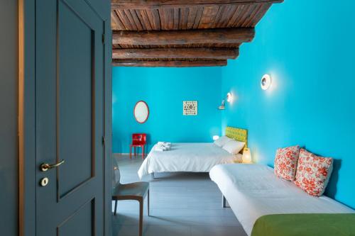 una camera con due letti e una parete blu di B&B AL LARGO a Pozzuoli