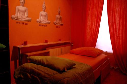 クヴェードリンブルクにあるReikistudio "Auszeit"のベッド2台、テーブル(瞑想サイン付)が備わる客室です。