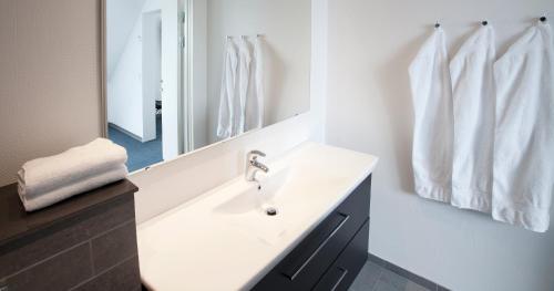 
a bathroom with a tub, sink and mirror at 62N Hotel - City Center in Tórshavn
