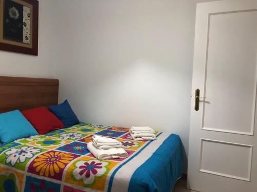 1 dormitorio con 1 cama colorida y toallas. en Vetonia Home, en Cáceres