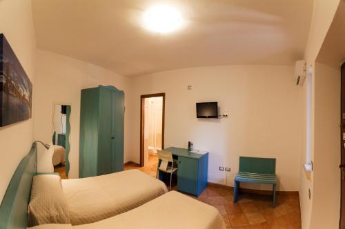 a hotel room with two beds and a desk at Villa dei Mercanti in Diamante