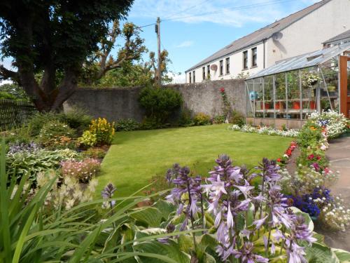 einen Garten vor einem Gebäude mit Blumen in der Unterkunft Nethercliffe Hotel in Wick