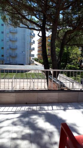 a bench sitting on a sidewalk next to a tree at Hotel Villa Dina in Lido di Jesolo