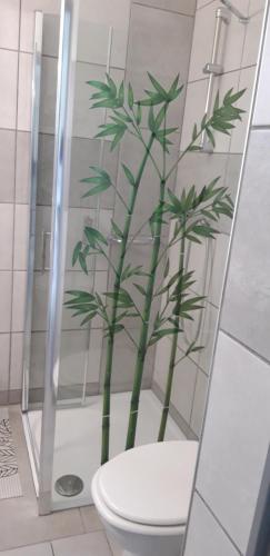 ein Bad mit einer Bambuspflanze in der Dusche in der Unterkunft Chez Celine in Rocamadour