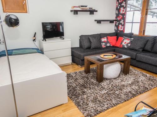 a living room with a couch and a table at Holiday Home Karhunvartijan linna a3 by Interhome in Ruka
