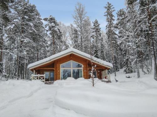 una cabaña de madera en el bosque en la nieve en Holiday Home Ritalahti by Interhome, en Jäniskylä