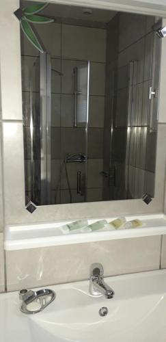 ein Waschbecken mit einem großen Spiegel darüber in der Unterkunft Chez Celine in Rocamadour