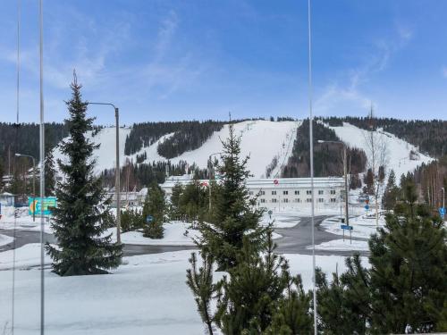 ein schneebedeckter Parkplatz mit Bäumen und einem Gebäude in der Unterkunft Holiday Home Tahko spa junior suite orange b2 by Interhome in Tahkovuori