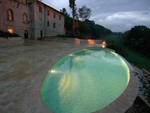 a large pool of green liquid in front of a building at Castello Montegiove in Fano