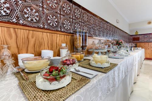 a buffet line with bowls and plates of food at Hotel Torre De Los Guzmanes in La Algaba