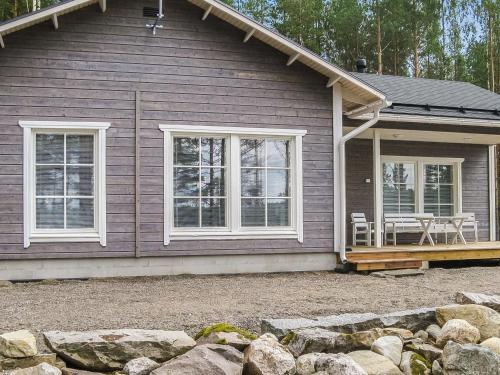 a house with a porch with a table and chairs at Holiday Home Koholahti by Interhome in Jäniskylä