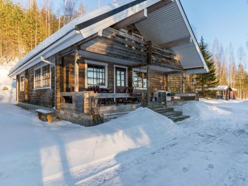 una cabaña de madera en la nieve en el bosque en Holiday Home Saarijärvi by Interhome, en Sipilä