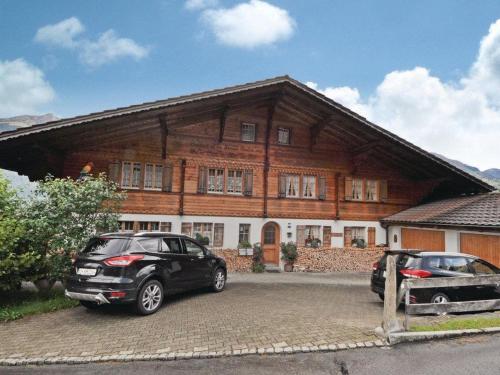 two cars parked in front of a house at Apartment Chalet Bodenweg by Interhome in Frutigen
