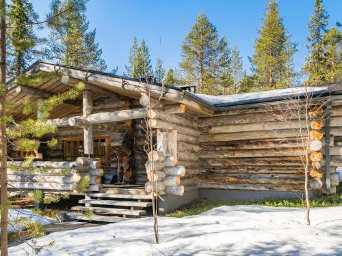a log cabin in the woods in the snow at Holiday Home Suutarinkolo by Interhome in Levi