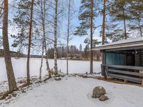 a cabin in the snow next to a lake at Holiday Home Aurinkoniemi by Interhome in Anttola