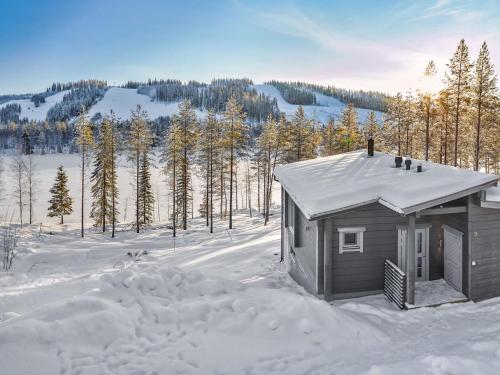 a small cabin in the snow with trees in the background at Holiday Home Villa ukkohalla by Interhome in Ukkohalla