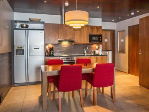 eine Küche mit einem Holztisch und roten Stühlen in der Unterkunft Holiday Home Tahko spa junior suite orange b2 by Interhome in Tahkovuori