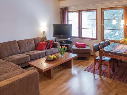 a living room with a couch and a table at Holiday Home Karhunvartijan linna a7 by Interhome in Ruka