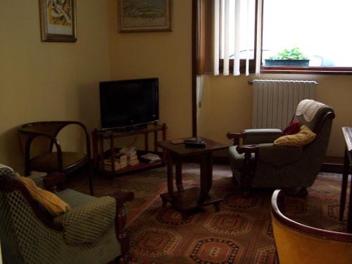a living room with chairs and a flat screen tv at Albergo Corona in Salsomaggiore Terme