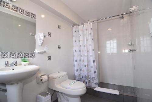 a bathroom with a toilet and a sink and a shower at Hotel Prisma Cusco in Cusco