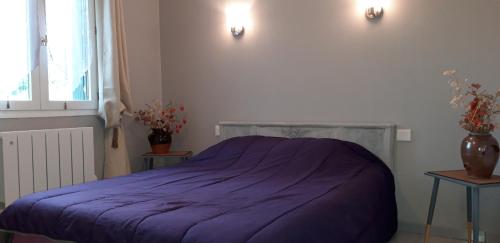 - une chambre avec un lit violet et 2 tables dans l'établissement Chez Celine, à Rocamadour