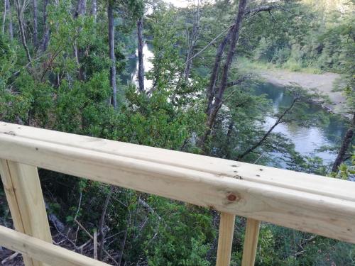 a view of a river from a wooden deck at Wonderful rustic cabin, with native trees, with Rio Trancura, equipped in Pucón