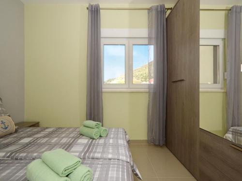 a bedroom with a bed with two green towels on it at sunshine in Trogir