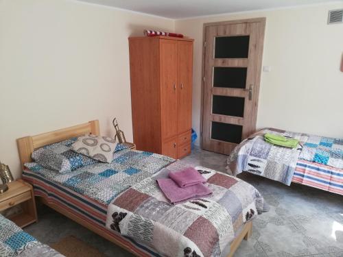 a bedroom with two beds and a dresser at Pokoje gościnne Zenon Nogal in Świnoujście