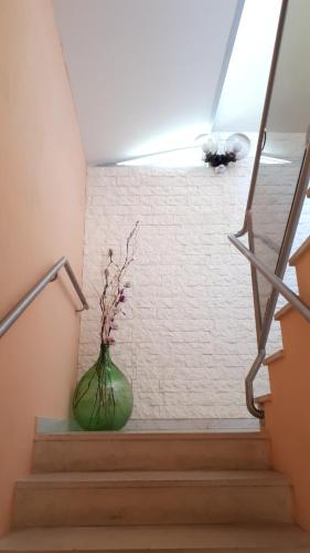a green vase with flowers sitting on the stairs at Hotel Villa Dina in Lido di Jesolo