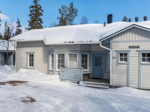 una pequeña casa blanca con nieve encima en Holiday Home Nelikko a by Interhome en Ruka